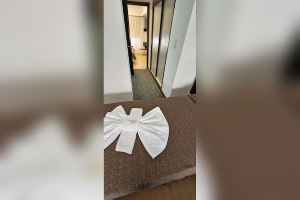 A hallway with a brown carpet and a white bow decoration on the floor.