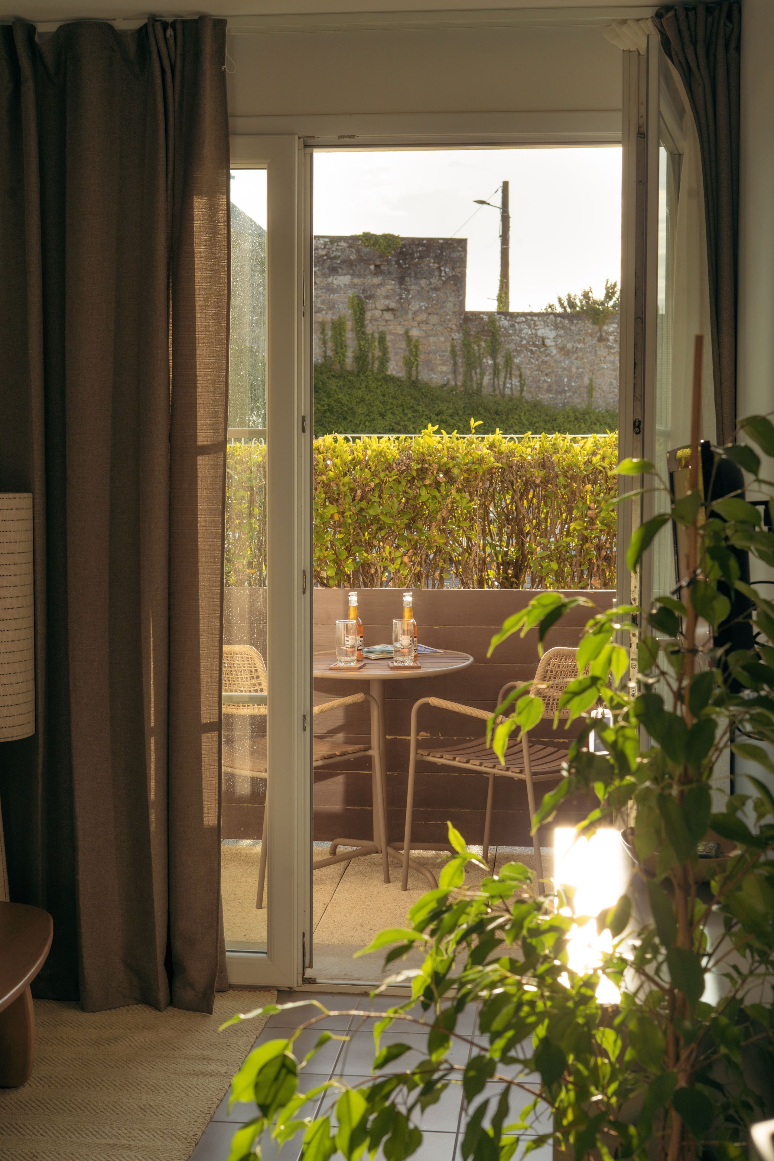 A room with a sliding glass door leading to an outdoor seating area with a table and chairs.