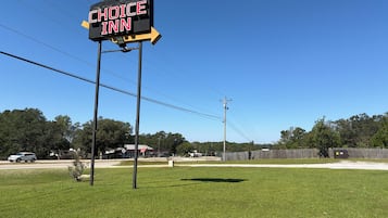 A sign for a Choice Inn hotel with a clear sky in the background.
