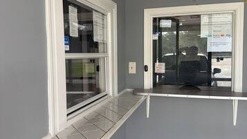 Una habitación con asiento incorporado junto a la ventana, ventilador de techo y vistas al exterior.