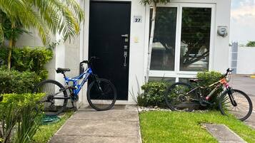 Un edificio residencial con una puerta negra, el número 27, y dos bicicletas estacionadas afuera.