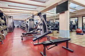 A gym with exercise equipment, a mirrored wall, and a red floor. - Cozy 1-bedroom hotel suite in Hacienda Del Mar Los Cabos (Cabo San Lucas)