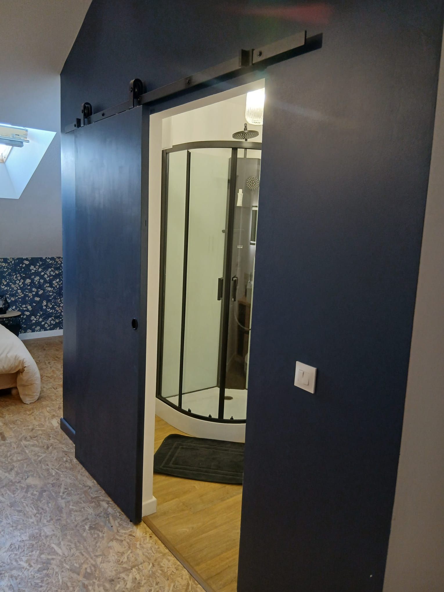 Une pièce dotée d’une porte coulissante donnant accès à un espace douche.