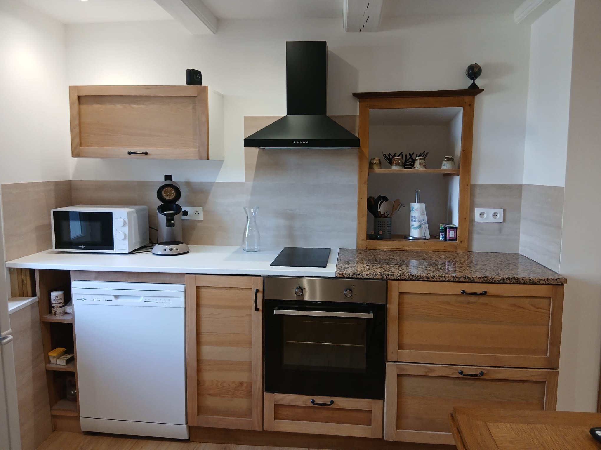 Cozinha compacta equipada com micro-ondas, cafeteira e forno.