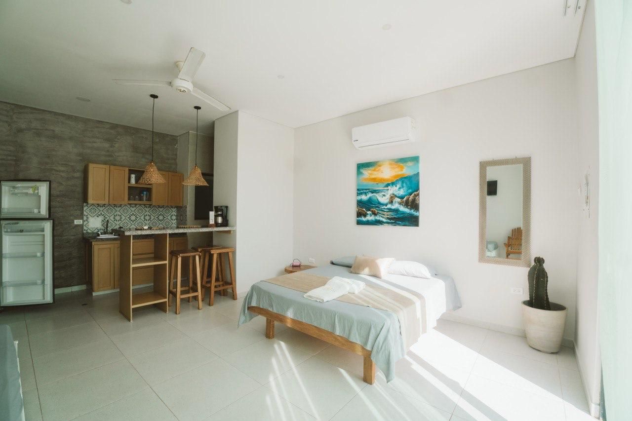 A modern bedroom with a bed, bedside table, and a large window.