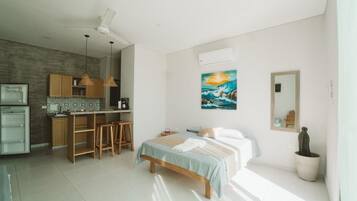 A modern bedroom with a bed, bedside table, and a large window.