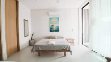 Une chambre à coucher avec un lit, une table de chevet, une plante en pot, un tableau et une porte coulissante.