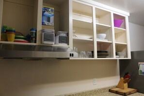 A kitchen with white cabinets, a stainless steel range hood, and various kitchenware. - LONG-TERM PRIVATE IN-LAW SUITE ON PARK (Halifax)