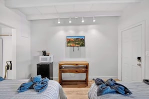 A hotel room with two beds, a wooden nightstand, a wall-mounted TV, and a door. - Highlander Room 3 Cozy Private Room in Williams (Williams)