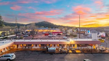 A motel with a swimming pool, a gas station, and a highlander motel in the background.
