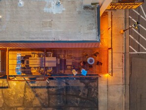 Vue aérienne d’un motel doté d’une terrasse en bois, de sièges en plein air et d’une enseigne indiquant « Highlander Motel ».