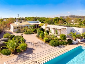 A modern villa with a swimming pool, surrounded by lush greenery and a clear sky. - Villa 'Casa Caranguejo' with Private Pool (Loulé)