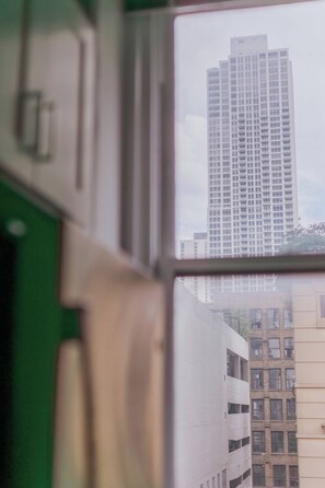 A view through a window of a high-rise building with multiple floors and a grid-like facade. - Designer Combo Loft 4E & 4W|Gold Coast/River North (Chicago)