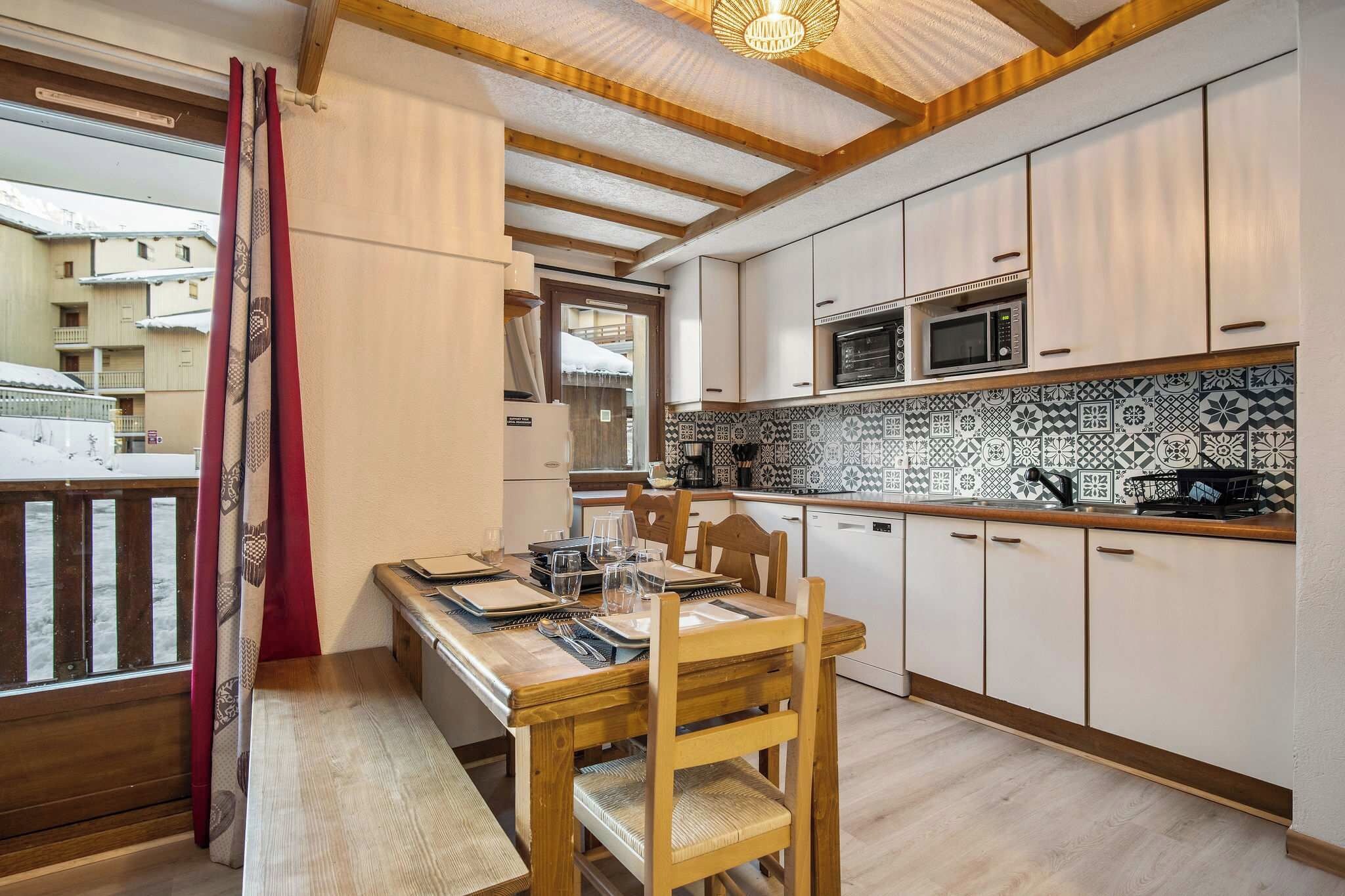 Une cuisine moderne avec des meubles blancs, un pare-feu décoré et un plancher en bois.