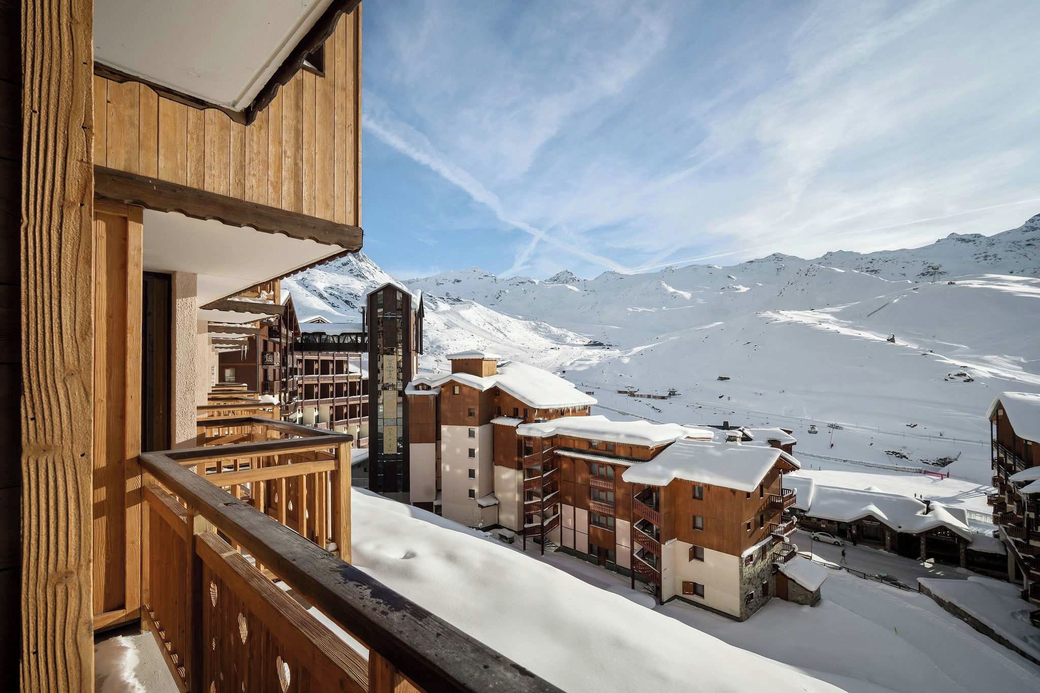 A snow-covered mountain town with wooden buildings and a ski slope in the background.