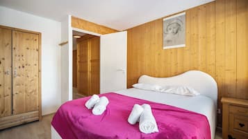 Un dormitorio con cama, armario de madera y panel de pared de madera.