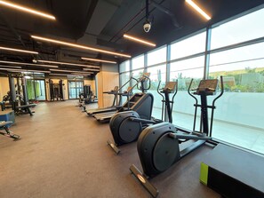 Ein Fitnessstudio mit Laufbändern, Kraftgeräten und Trainingsausrüstung.