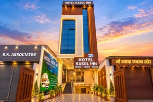 A hotel with a modern design, featuring a prominent vertical entrance, a signboard with the hotel name, and a checkered floor pattern.