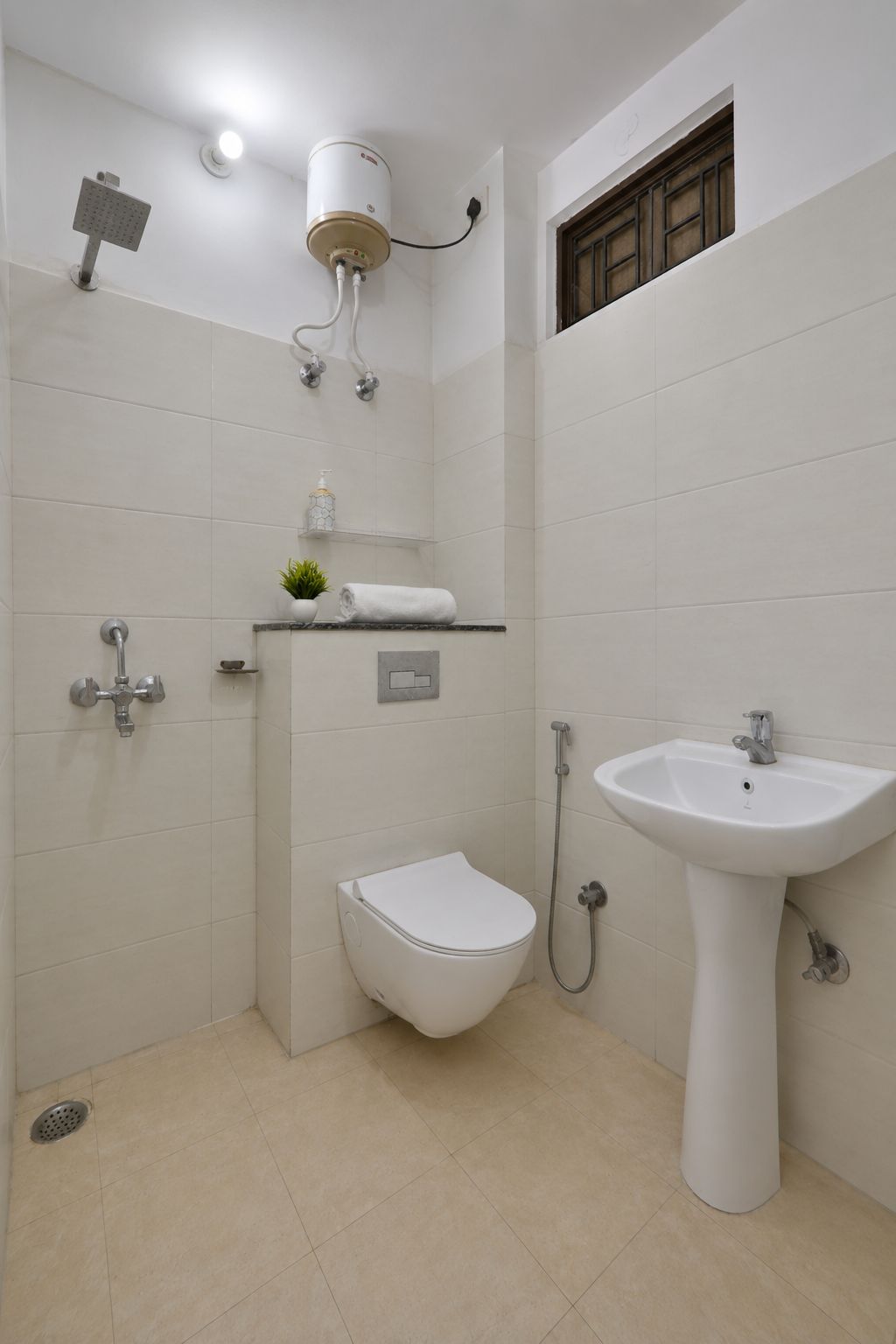 A bathroom with a toilet, bidet, shower, and sink.