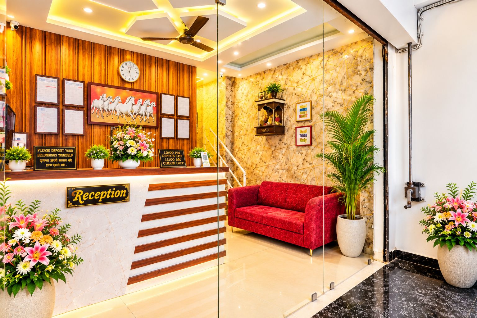 A reception area with a wooden panel wall, a clock, framed documents, and a red sofa.