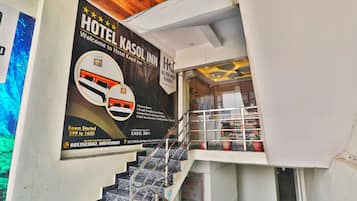 Interior de un hotel con una escalera que conduce a la recepción.