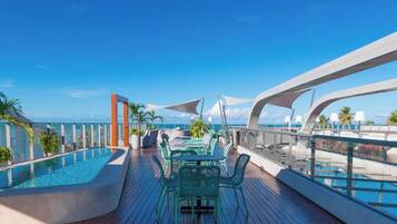 Cubierta de crucero con piscina, mobiliario exterior y vistas al océano.