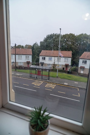 En boligvej med huse, et busstoppested og en fri vej.