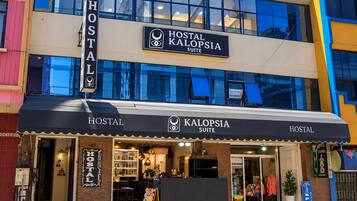 A building with a sign for 'HOSTAL KALOPSIA SUITE' indicating a hotel or hostel.