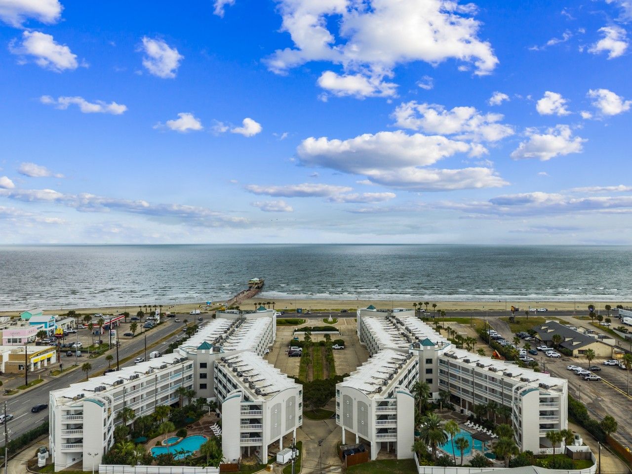 Un hôtel situé sur la côte, doté d’une piscine, de plusieurs étages et offrant une vue sur la plage et l’océan.