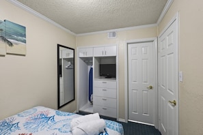 Ein Hotelzimmer mit Bett, Schrank, Spiegel und Tür.