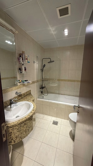 Kylpyhuone, jossa on pesuallas, peili, suihku ja wc.