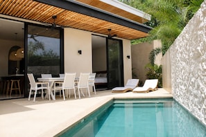 A modern outdoor pool area with a dining set and lounge chairs. - Casa Solea | Luxury Eco Villa in Playa Pelada (Nosara)