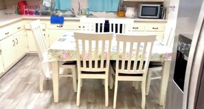A kitchen with a dining table and chairs, a microwave, and a refrigerator. - 3-bedroom house in charming Salisbury with cool AC (Salisbury)