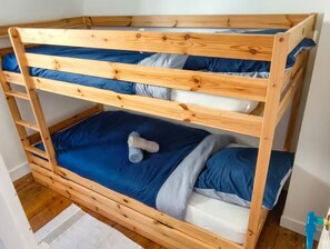 A bunk bed with three levels, each with a blue mattress and pillows. - Le Temps des Violettes - 3-Bedroom Apartment in the Heart of Downtown with a View of the Harbor Towers (Trouville-sur-Mer)
