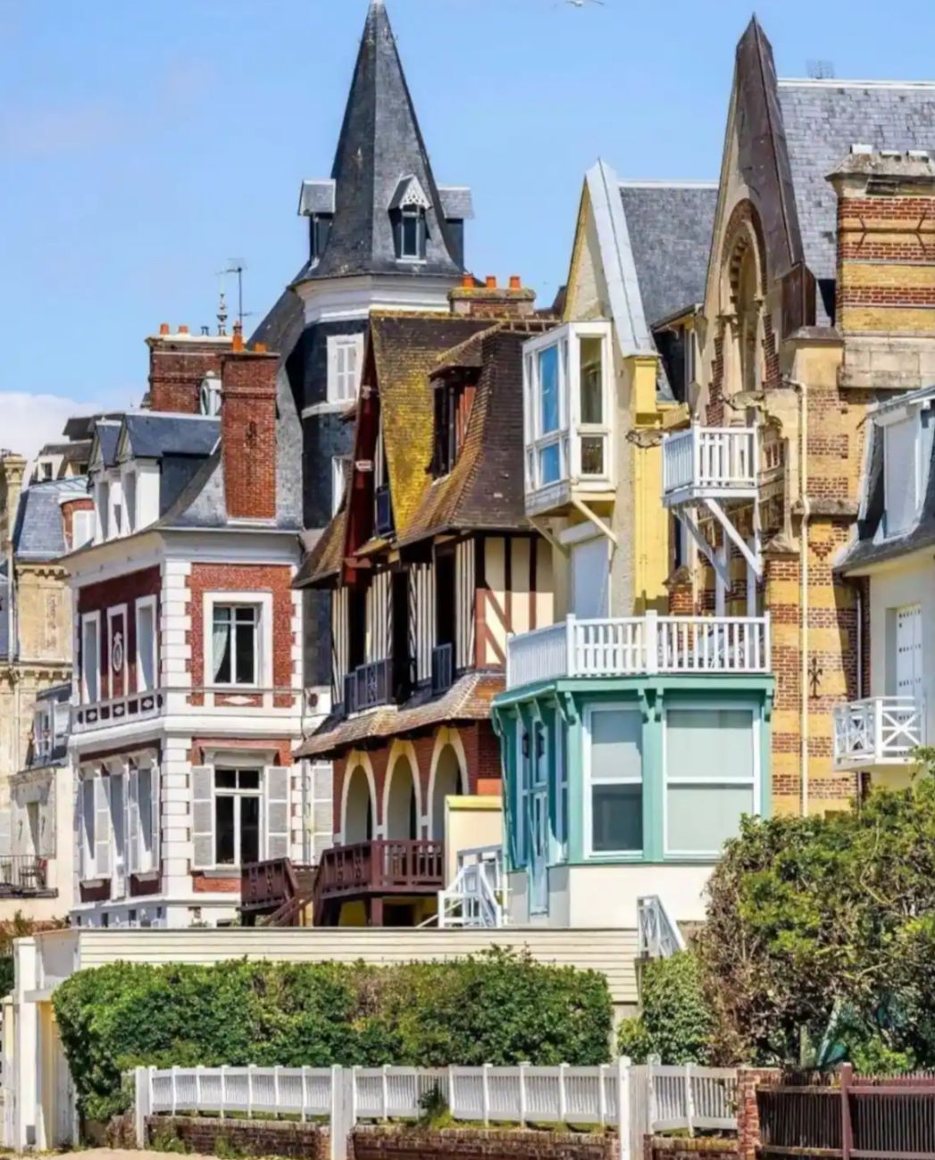 A row of multi-story buildings with varying architectural styles, including gabled roofs and dormer windows.