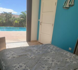 Une chambre avec un lit, une porte et une vue sur une piscine.