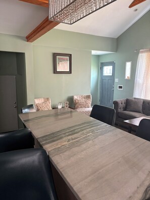 A dining area with a long table, chairs, and a ceiling fan. - Midway comfortable home that sleeps 10. 5 mins to MDW; 15 mins to dwtn. (Chicago)