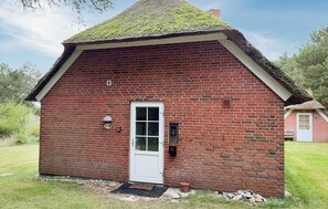 A small brick building with a thatched roof, a white door, and a small window. - Nice home in Ulfborg with WiFi (Ulfborg)