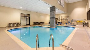 A swimming pool with a tiled border, a central pillar, and multiple seating areas with chairs. - Elegant Georgetown Retreat | Hilton 1BR Suite | Walk to Shops & Dining (Washington)