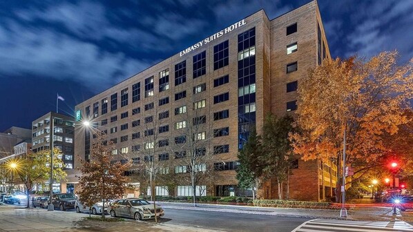A multi-story building with the sign "EMBASSY SUITES HOTEL" indicating it is a hotel. - Elegant Georgetown Retreat | Hilton 1BR Suite | Walk to Shops & Dining (Washington)