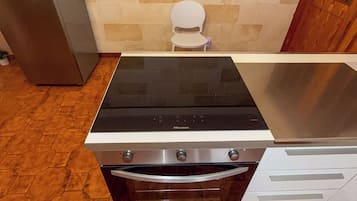 Une cuisine équipée d’une cuisinière, d’un four et d’un réfrigérateur en acier inoxydable.