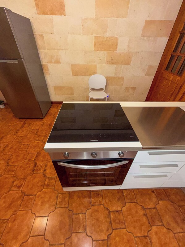 Una cocina con estufa, horno y refrigerador de acero inoxidable.