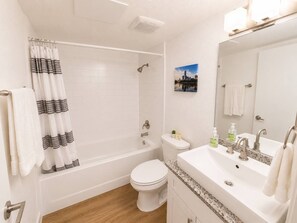 Une salle de bain avec une baignoire, des toilettes, un lavabo et un miroir.