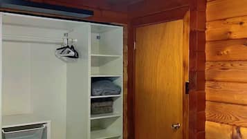 A bedroom with a bed, a wardrobe, and a ceiling fan.