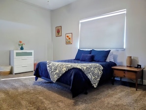 A bedroom with a bed, a nightstand, a dresser, and a window with blinds. - Flagstaff Family Home with Playroom & Snowbowl (Flagstaff)