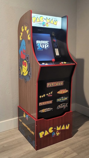 A Pac-Man arcade machine with a wooden finish and colorful graphics.