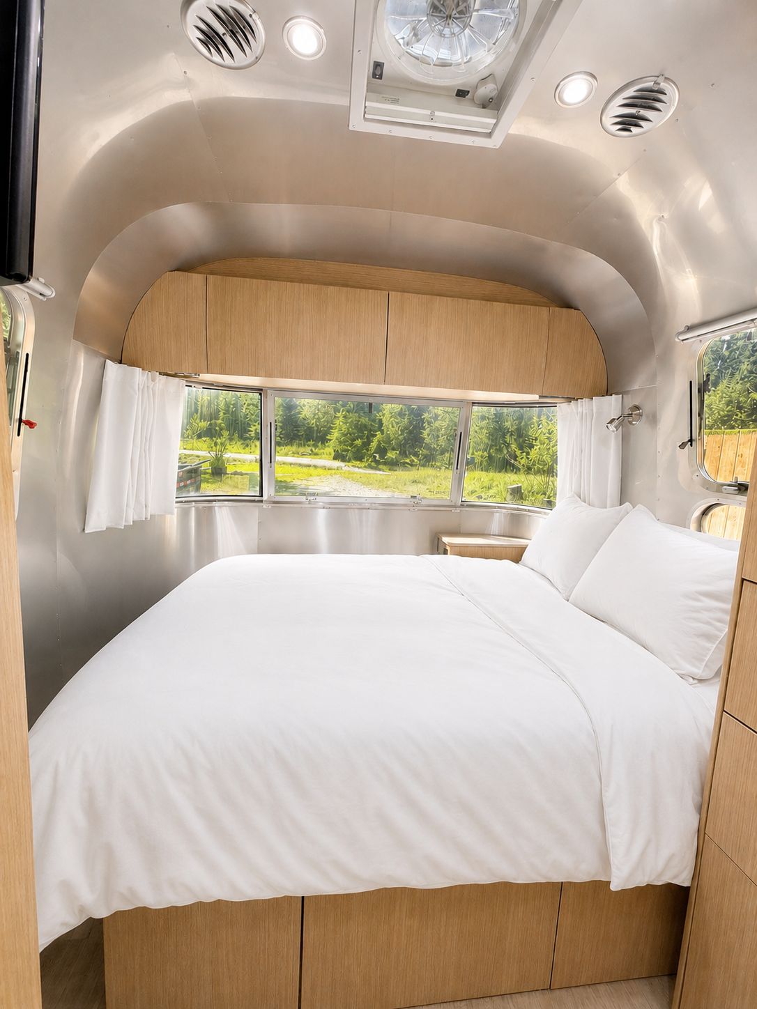 A bedroom with a bed, a window, and a skylight.