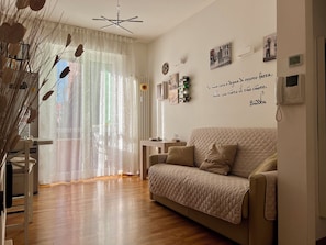 A living room with a sofa, a coffee table, and a wall with motivational quotes. - Nido Milano | La tua casa lontano da casa (Milano)