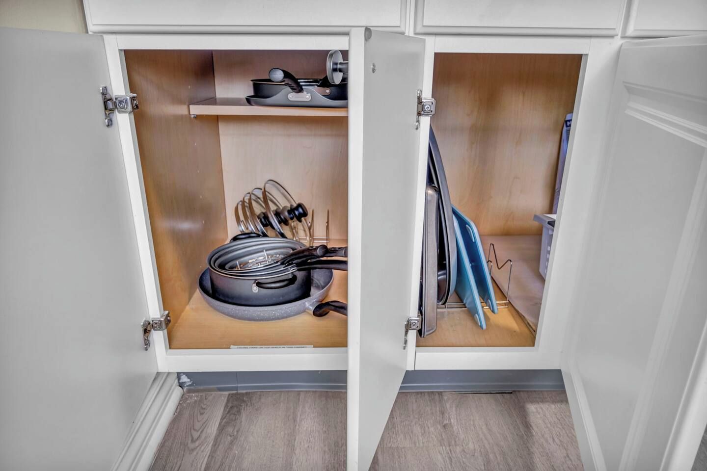 Un armario de cocina con estufa, ollas y utensilios.