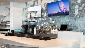 Eine Bar mit einer Mosaikwand, einem großen Bildschirm, der eine Strand Szene zeigt, und einem Bild von einem Riesenrad.